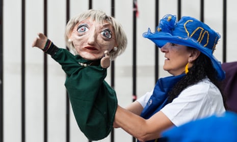 An anti-Brexit protester holds up a puppet of Theresa May