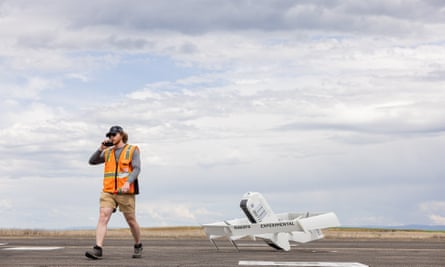 Amazon enters the age of robots. What does that imply for its staff? | Amazon 1 Amazon worker outside with drone behind him.