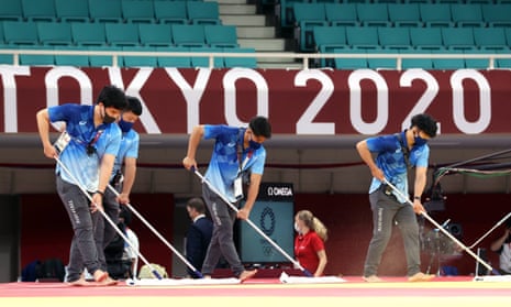 Technicians clean the floor of the judo arena