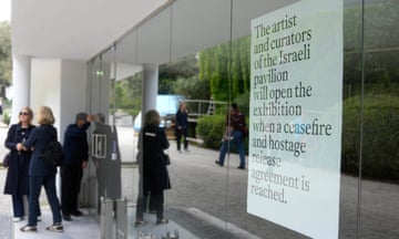 People stand in front of the closed Israeli national pavilion at the Biennale contemporary art fair in Venice, Italy.
