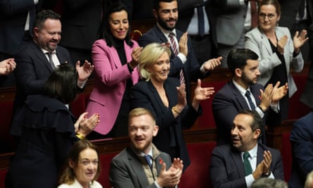French far-right leader Marine Le Pen, centre, applauds with other National Rally parliament members ahead of the no-confidence motion