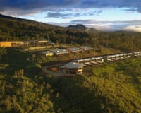 Three rows of hotel buildings set on shelves excavated into a forest-covered hillside