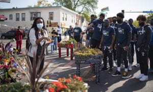 Jeanelle Austin, left, explains and interprets the George Floyd memorial site for a group of Minnesota Timberwolves players in October 2020.