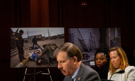 Photographs showing victims of Russia’s war on Ukraine are seen in the background while Eli Rosenbaum responds to questions during a Senate judiciary committee hearing on Ukraine war crimes in September.