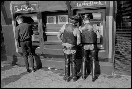 Des hommes vêtus de cuir obtiennent de l'argent à un distributeur automatique de billets