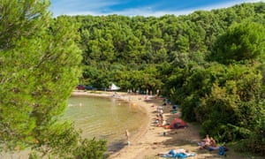 Tourists on in Maslinica cove beach