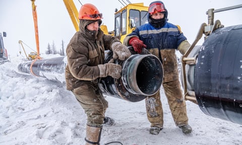 Workers connect a pipeline over permafrost at a site in Novy Urengoy, Siberia.
