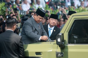 President Prabowo Subianto sign a document on the bonnet of a Pandu, an electric military vehicle