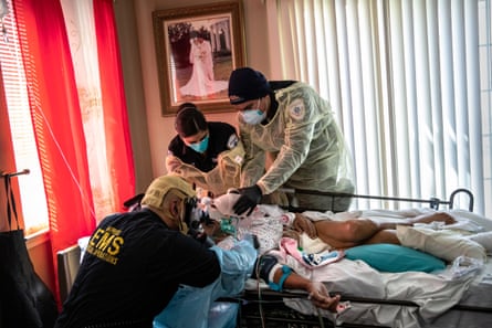 Medics intubate a gravely ill patient with Covid-19 symptoms at his home in Yonkers, New York, on 6 April 2020.