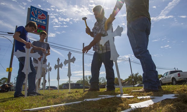 People hammer in crosses at the VP Racing Fuels gas station just down the road from the First Baptist church of Sutherland Springs.