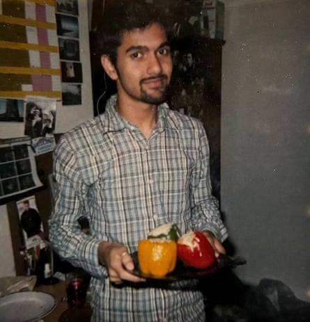 Manish holds a plate of stuffed peppers