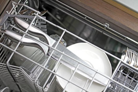Dishwasher after cleaning process with large kitchen knives at the top