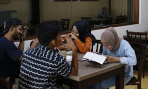 People sit at a restaurant in BireuÃ«n, a district in Aceh province