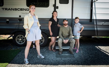 Two parents, a girl of about 9 and Dooley stand outside a trailer