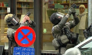 Armed officers take part in a raid in the Molenbeek neighborhood of Brussels.