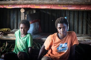 Children watch as their dried kava is weighed. Everyone participates in the lucrative kava trade. But now the storm has destroyed crops, which will take years to re-grow.