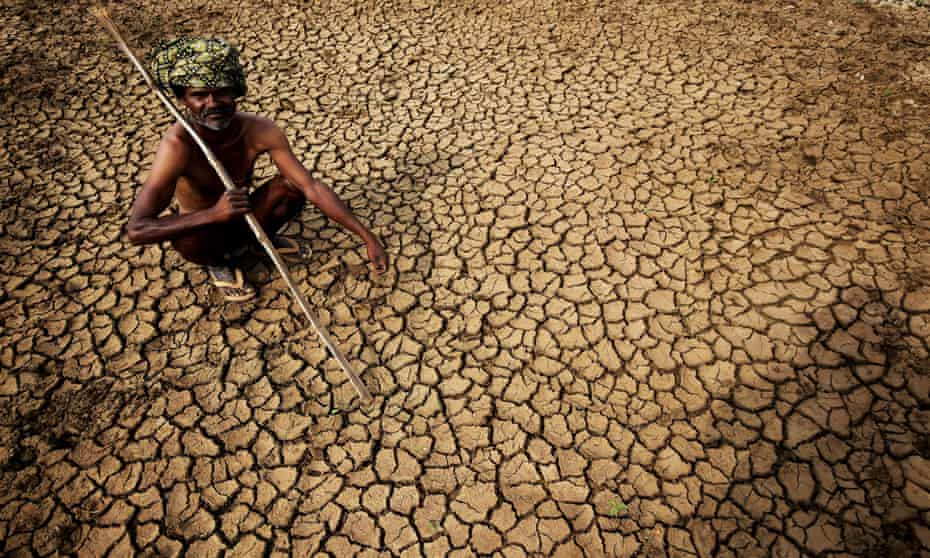 A farmer sits on his dried-up land near Andhra Pradesh