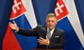 Robert Fico speaks at a conference in front of the Slovakian flag