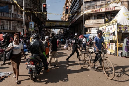 Pedestrians pass electoral posters of Yoweri Museveni, Uganda’s president, in central Kampala, Uganda