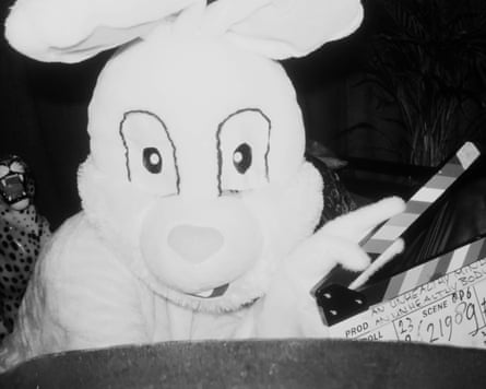 A person in a rabbit costume holding a clapperboard