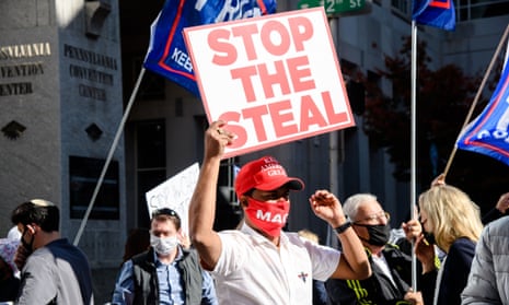 trump supporter holds sign saying 'stop the steal'