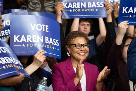 Karen Bass claps as supporters stand behind her holding signs that say ‘vote Karen Bass for mayor’
