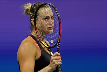 Aryna Sabalenka looks dejected behind her racket on court