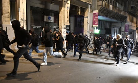 Protesters run during clashes with riot police in Athens on Tuesday night