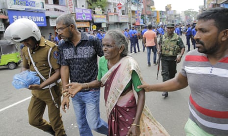 Sri Lankan elderly woman is helped near St. Anthony’s Shrine after a blast in Colombo, Sri Lanka, Sunday, April 21, 2019. Dozens of people were killed and hundreds wounded in near simultaneous blasts that rocked three churches and three hotels in Sri Lanka on Easter Sunday, officials said. (AP Photo/Eranga Jayawardena)