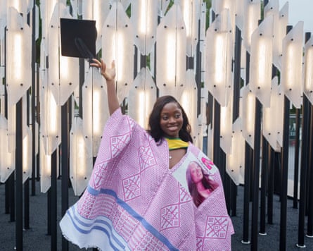 A female graduand throws her mortar board hat in the air after her graduation ceremony at the Festival Hall on the South Bank.