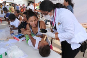 Some of the thousands of Central American migrants in the caravan receive medical attention after arriving into a camp for the evening in Juchitan de Zaragoza, Mexico