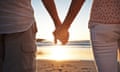 A couple holding hands on a beach