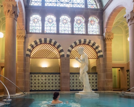 A woman in a thermal pool with a statue