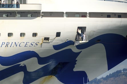 Crew members wear masks while preparing to dock the Grand Princess in Oakland.