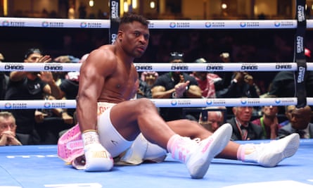 Francis Ngannou sits stunned after being floored by Anthony Joshua in the first round.