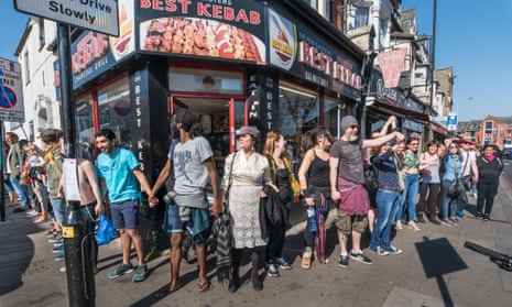 People form a human chain around the block containing the Latin Village at a protest in 2017.