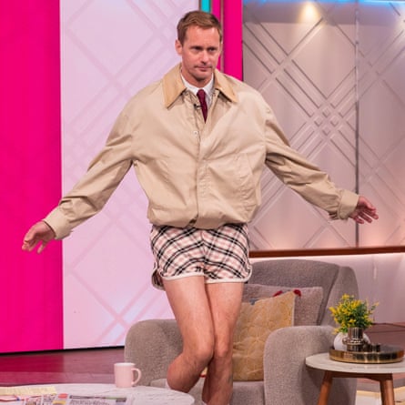 Actor Alexander Skasgaad, wearing short shorts with shirt and tie and a bomber jacket while appearing on the ITV morning show Lorraine.
