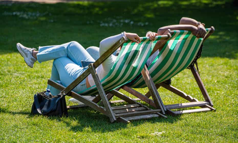 People relaxing in the spring sunshine in Saint James Park, London