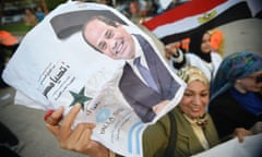 A woman holds a photo of Egyptian president Abdel Fattah al-Sisi after he wins third term in office