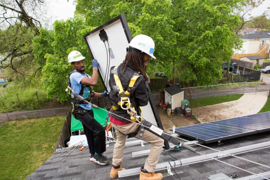 Antwain Nelson (left) and Andre Hinton (right), both workers with Grid Alternatives, install a solar panel at a home in Washington DC in May 2016.