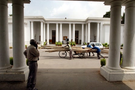 Workers wheel cut lengths of bamboo through the grounds of the Gymkhana club