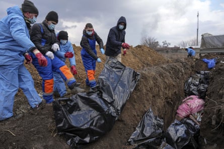 Bodies of those killed are placed into a mass grave on the outskirts of Mariupol, 9 March