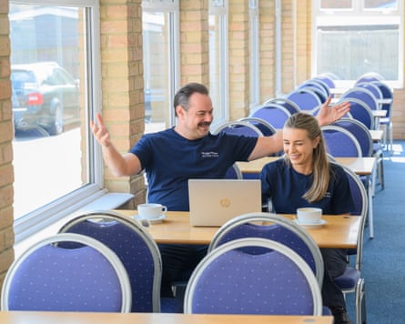 Father and daughter sit in a deserted caravan park cafe with a laptop