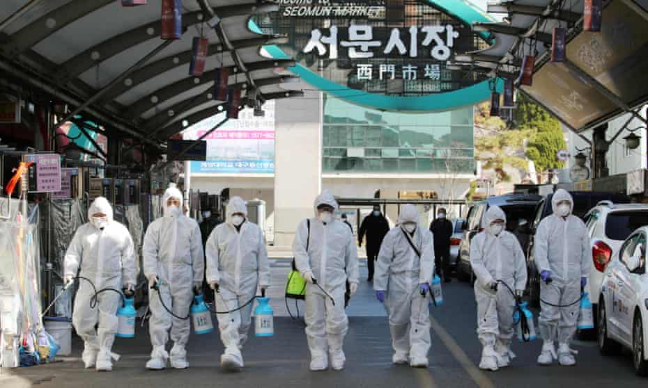 Coronavirus outbreak: workers spray a market in Daegu, the centre of the South Korea infections, on Sunday.