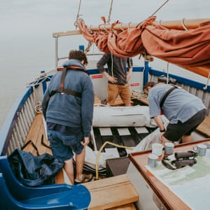 Preparing the inflatable dinghy onboard, in order to reach the sandbank with cooking utensils.