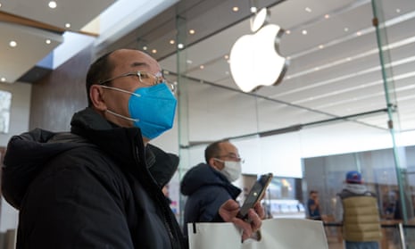 People wearing face masks walk past an Apple store in Brossard, on the south shore of Montreal, Canada