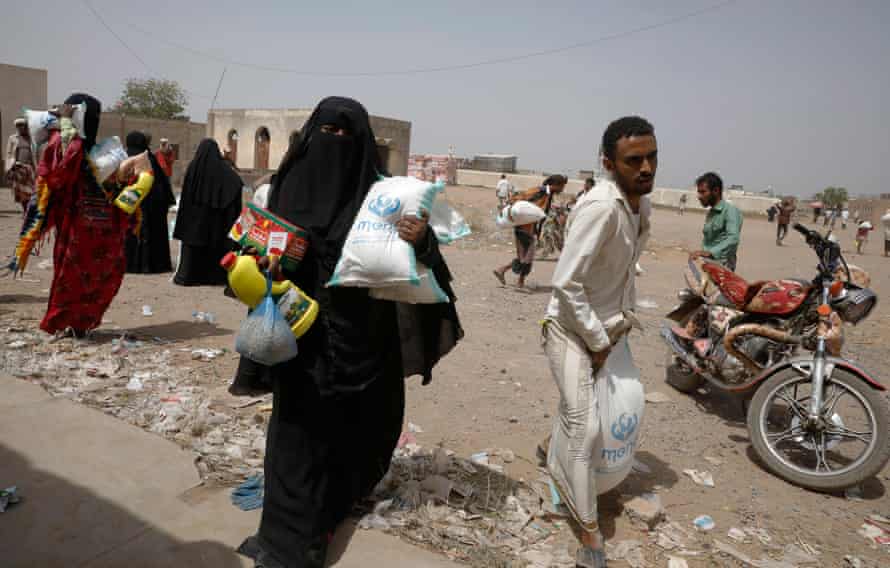 People receive food aid at al-Jarahi town, in the port province of Hodeidah, Yemen, 10 February 2022