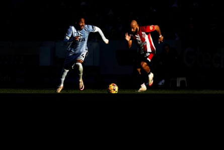 Djed Spence of Tottenham runs with the ball whilst under pressure from Bryan Mbeumo of Brentford