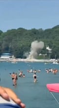 Mobile phone footage of people in the sea looking at smoke rising from the beach