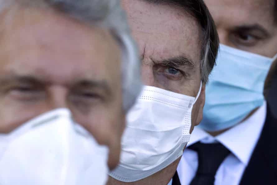 Bolsonaro, center, arrives for a press conference following a meeting about the federal government’s response to coronavirus in Brasilia on Wednesday.